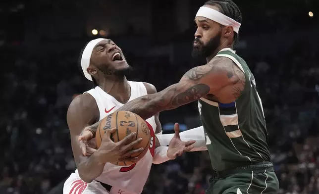 Toronto Raptors guard Immanuel Quickley, left, and Milwaukee Bucks guard Gary Trent Jr. vie for control of the ball during the first half of an NBA basketball game in Toronto, Monday, Jan. 6, 2025. (Nathan Denette/The Canadian Press via AP)