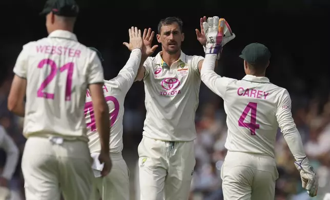 Australia's Mitchell Starc is congratulated by teammates after taking the wicket of India's Ravindra Jadeja during play on the first day of the fifth cricket test between India and Australia at the Sydney Cricket Ground, in Sydney, Australia, Friday, Jan. 3, 2025. (AP Photo/Mark Baker)