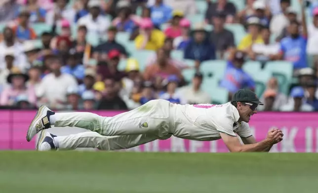 Australia's captain Pat Cummins dives to take a catch to dismiss India's Rishabh Pant during play on the first day of the fifth cricket test between India and Australia at the Sydney Cricket Ground, in Sydney, Australia, Friday, Jan. 3, 2025. (AP Photo/Mark Baker)