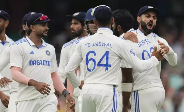 India's Virat Kohli, right, celebrates with Jasprit Bumrah after the wicket Australia's Usman Khawaja during play on the first day of the fifth cricket test between India and Australia at the Sydney Cricket Ground, in Sydney, Australia, Friday, Jan. 3, 2025. (AP Photo/Mark Baker)