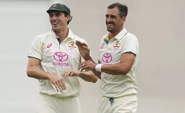 Australia's captain Pat Cummins, congratulated teammate Mitchell Starc after taking the wicket of India's KL Rahul during play on the first day of the fifth cricket test between India and Australia at the Sydney Cricket Ground, in Sydney, Australia, Friday, Jan. 3, 2025. (AP Photo/Mark Baker)