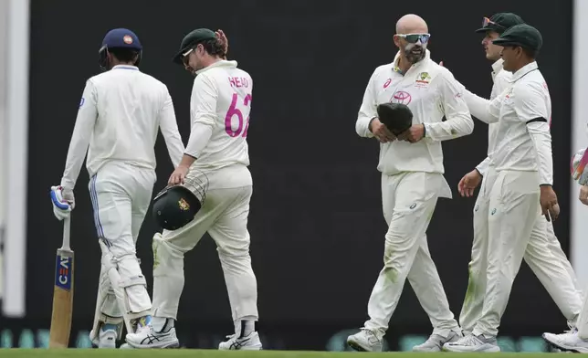 Australia's Nathan Lyon, second right, is congratulated by Australia's Usman Khawaja after taking the wicket of India's Shubman Gill, left, during play on the first day of the fifth cricket test between India and Australia at the Sydney Cricket Ground, in Sydney, Australia, Friday, Jan. 3, 2025. (AP Photo/Mark Baker)