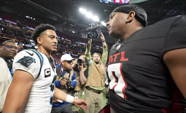 Carolina Panthers quarterback Bryce Young and Atlanta Falcons quarterback Michael Penix Jr. meet after overtime in an NFL football game, Sunday, Jan. 5, 2025, in Atlanta. (AP Photo/Brynn Anderson)