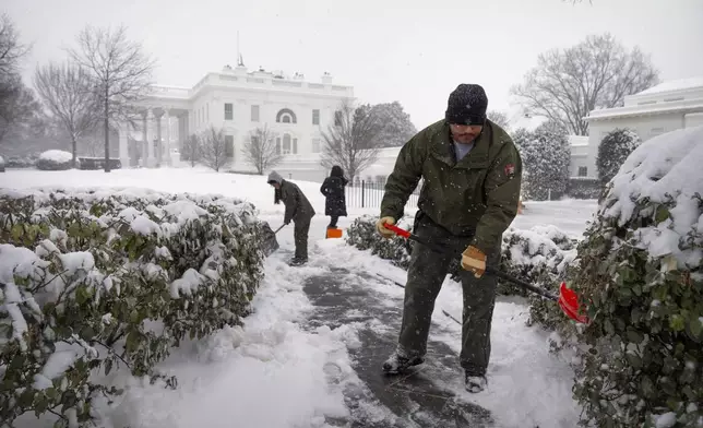 National Park Service workers shovel a pathway during a winter storm at the White House, Monday, Jan. 6, 2025, in Washington. (AP Photo/Mark Schiefelbein)