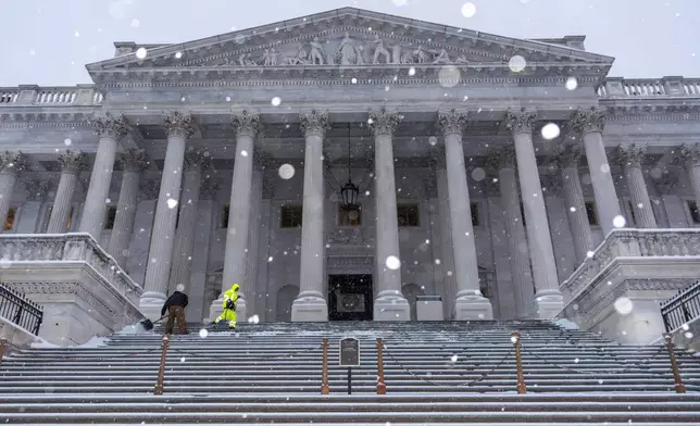 Workers clear steps at the Capitol as snow falls ahead of a joint session of Congress to certify the votes from the Electoral College in the presidential election, in Washington, Monday, Jan. 6, 2025. (AP Photo/J. Scott Applewhite)