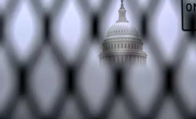 The Capitol is seen through a security fence as snow blankets Capitol Hill ahead of a joint session of Congress to certify the votes from the Electoral College in the presidential election in Washington, Monday, Jan. 6, 2025. (AP Photo/Jose Luis Magana)