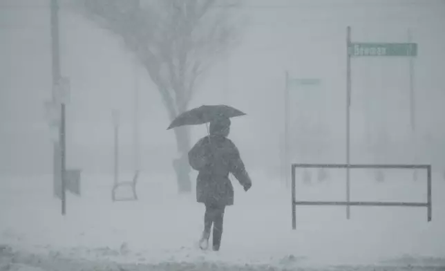 A person holds an umbrella as they walk during a winter storm, Monday, Jan. 6, 2025, in Cincinnati. (AP Photo/Joshua A. Bickel)