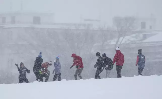 People engage in a snowball fight during a winter snow storm in Washington, Monday, Jan. 6, 2025. (AP Photo/Matt Rourke)