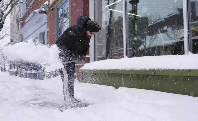 Jagmeet Singh, a manager at Clifton Market, shovels the sidewalk in front of the store during a winter storm, Monday, Jan. 6, 2025, in Cincinnati. (AP Photo/Joshua A. Bickel)