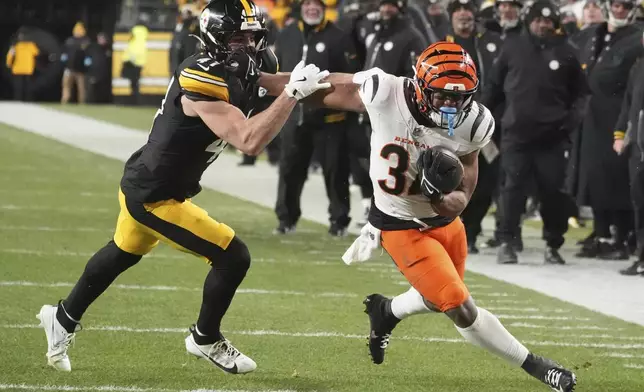 Cincinnati Bengals running back Khalil Herbert (34) runs with the ball as Pittsburgh Steelers linebacker Payton Wilson (41) defends during the second half of an NFL football game in Pittsburgh, Saturday, Jan. 4, 2025. (AP Photo/Gene J. Puskar)