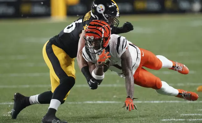 Cincinnati Bengals wide receiver Ja'Marr Chase (1) picks up a first down defended by Pittsburgh Steelers linebacker Alex Highsmith (56) during the first half of an NFL football game in Pittsburgh, Saturday, Jan. 4, 2025. (AP Photo/Matt Freed)