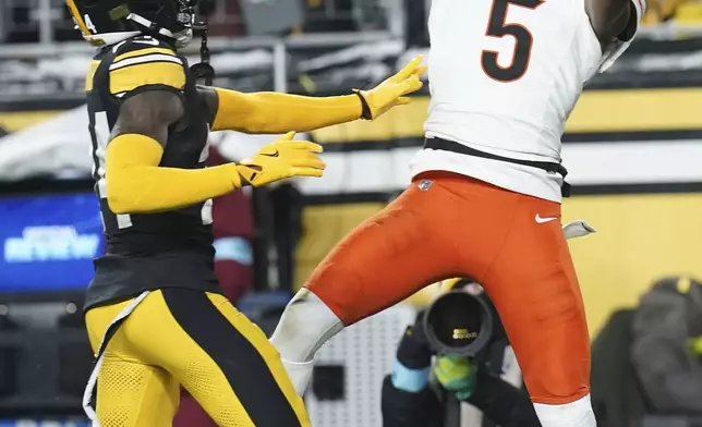 Cincinnati Bengals wide receiver Tee Higgins (5) catches a pass in front of Pittsburgh Steelers cornerback Joey Porter Jr. (24) during the first half of an NFL football game in Pittsburgh, Saturday, Jan. 4, 2025. (AP Photo/Matt Freed)