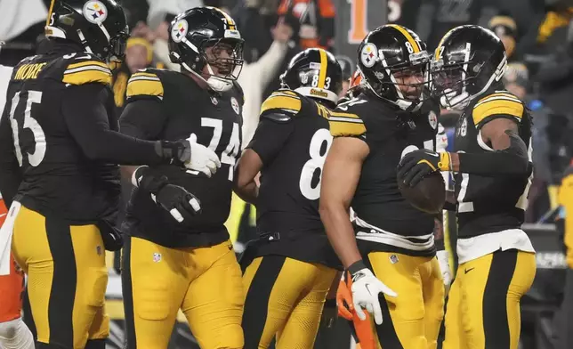 Pittsburgh Steelers running back Najee Harris (22), right, celebrates scoring a touchdown with offensive tackle Dan Moore Jr. (65), guard Spencer Anderson (74), tight end Connor Heyward (83), and tight end MyCole Pruitt (81), during the first half of an NFL football game against the Cincinnati Bengals in Pittsburgh Saturday, Jan. 4, 2025. (AP Photo/Gene J. Puskar)