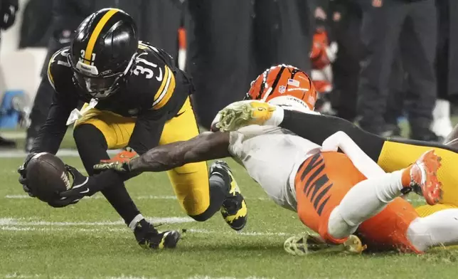 Pittsburgh Steelers cornerback Beanie Bishop Jr., left, intercepts a pass intended for Cincinnati Bengals wide receiver Ja'Marr Chase, center, that was broken up by Steelers linebacker Patrick Queen, right, during the first half of an NFL football game in Pittsburgh Saturday, Jan. 4, 2025. (AP Photo/Gene J. Puskar)