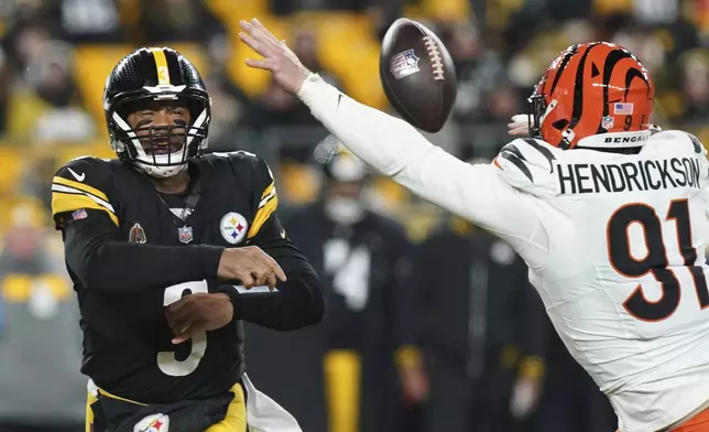 Pittsburgh Steelers quarterback Russell Wilson (3) throws a pass as Cincinnati Bengals defensive end Trey Hendrickson (91) moves in during the first half of an NFL football game in Pittsburgh, Saturday, Jan. 4, 2025. (AP Photo/Matt Freed)