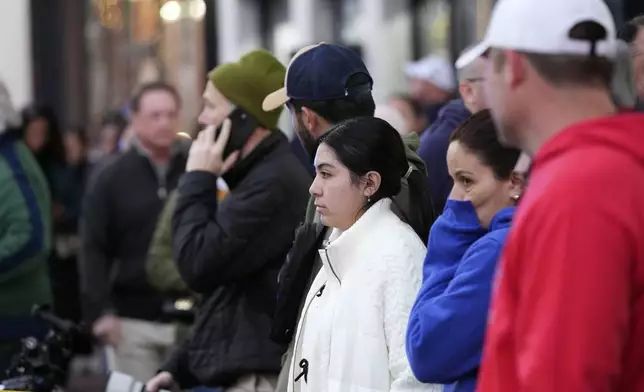 People look on at the scene after a vehicle drove into a crowd on New Orleans' Canal and Bourbon Street, Wednesday Jan. 1, 2025. (AP Photo/Gerald Herbert)