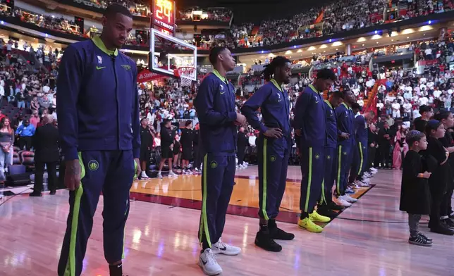 New Orleans Pelicans players stand during a tribute at the Kaseya Center for people killed after a vehicle drove into a crowd in New Orleans before an NBA basketball game between the Miami Heat and the New Orleans Pelicans, Wednesday, Jan. 1, 2025, in Miami. (AP Photo/Lynne Sladky)