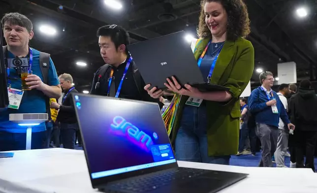 Rebecca Isaacs checks out the new LG gram 2-in-1 convertible laptop offering the versatility of both a laptop and tablet during 2025 CES Unveiled, Sunday, Jan. 5, 2025, in Las Vegas. (AP Photo/Jack Dempsey)