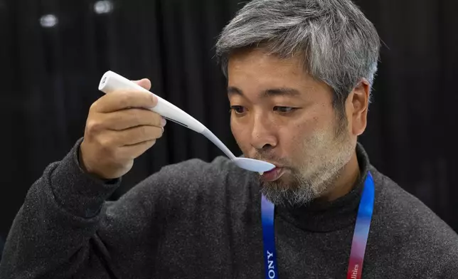 Kiyohiro Izumo uses the Kirin Electric Salt spoon which intensifies salt flavor by flowing a mild electric current through the food around the tongue to attract salt towards the tongue, during 2025 CES Unveiled, Sunday, Jan. 5, 2025, in Las Vegas. (AP Photo/Jack Dempsey)