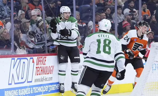 Dallas Stars' Mavrik Bourque (22) and Sam Steel (18) celebrate past Philadelphia Flyers' Nick Seeler (24) after Bourque's goal during the first period of an NHL hockey game, Thursday, Jan. 9, 2025, in Philadelphia. (AP Photo/Matt Slocum)