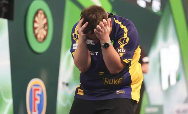 Luke Littler of England celebrates after winning the final against Michael van Gerwen of the Netherlands at the World Darts Championship at Alexandra Palace in London, Friday, Jan. 3, 2025. (AP Photo/Kirsty Wigglesworth)