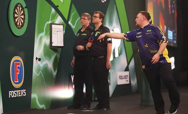 Luke Littler of England throws his dart during the final of the World Darts Championship at Alexandra Palace in London, Friday, Jan. 3, 2025. (AP Photo/Kirsty Wigglesworth)