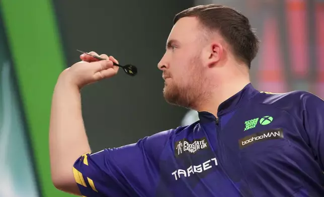 Luke Littler of England throws his dart during the final of the World Darts Championship at Alexandra Palace in London, Friday, Jan. 3, 2025. (AP Photo/Kirsty Wigglesworth)