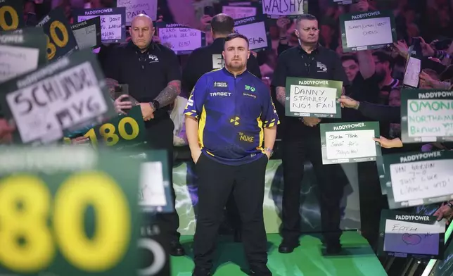 Luke Littler of England stands before the final of the World Darts Championship at Alexandra Palace in London, Friday, Jan. 3, 2025. (AP Photo/Kirsty Wigglesworth)