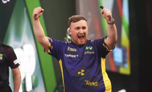 Luke Littler of England celebrates after winning the final against Michael van Gerwen of the Netherlands at the World Darts Championship at Alexandra Palace in London, Friday, Jan. 3, 2025. (AP Photo/Kirsty Wigglesworth)