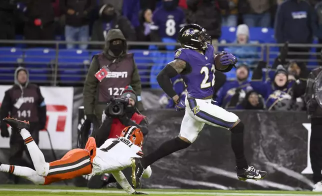 Baltimore Ravens running back Derrick Henry, right, scores past Cleveland Browns safety Juan Thornhill (1) on a 43-yard touchdown run during the second half of an NFL football game Saturday, Jan. 4, 2025, in Baltimore. (AP Photo/Nick Wass)