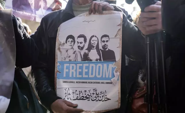 Activists and relatives take part in a protest demanding answers to whereabouts of four activists who disappeared during the war between opposition forces and Asasd regime, in Douma, Syria, Wednesday, Jan. 1, 2025. (AP Photo/Mosa'ab Elshamy)