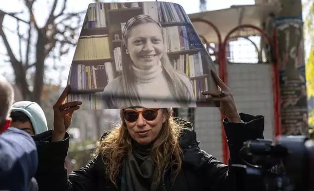 A woman holds a portrait of Razan Zaitouneh who disappeared during the war between opposition groups and former President Bashar Assad's forces, during a protest in Douma, Syria, Wednesday, Jan. 1, 2025. (AP Photo/Mosa'ab Elshamy)