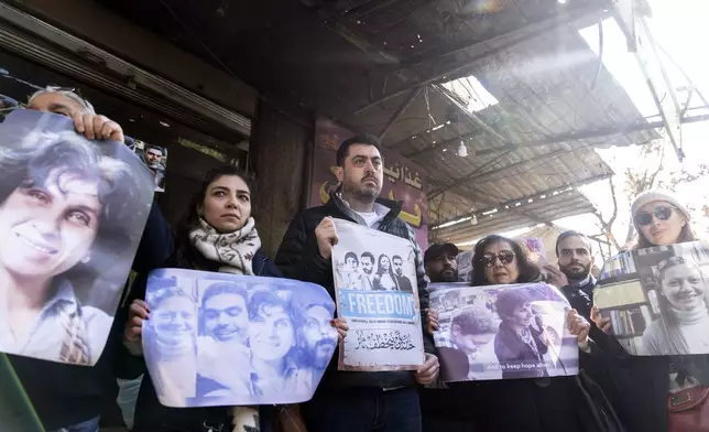 Activists and relatives take part in a protest demanding the whereabouts of four activists who disappeared during the war between opposition groups and former President Bashar Assad's forces, in Douma, Syria, Wednesday, Jan. 1, 2025. (AP Photo/Mosa'ab Elshamy)