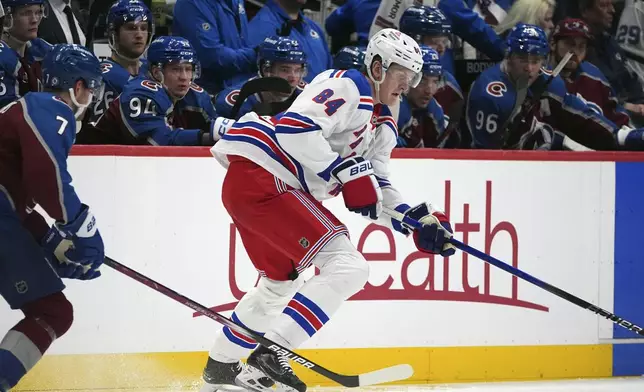 New York Rangers center Adam Edstrom, right, collects the puck as Colorado Avalanche defenseman Devon Toews covers in the second period of an NHL hockey game, Tuesday, Jan. 14, 2025, in Denver. (AP Photo/David Zalubowski)