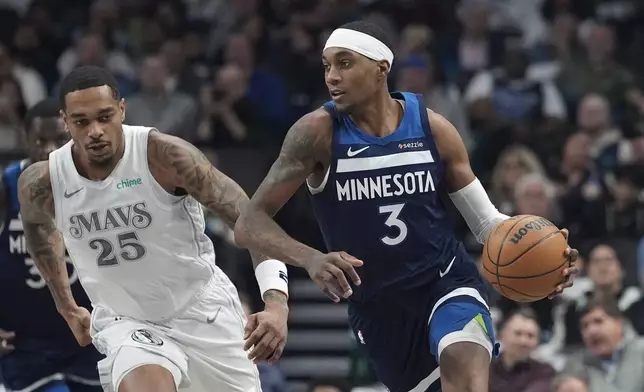 Minnesota Timberwolves forward Jaden McDaniels (3) drives past Dallas Mavericks forward P.J. Washington (25) during the first half of an NBA basketball game Wednesday, Jan. 22, 2025, in Dallas. (AP Photo/LM Otero)