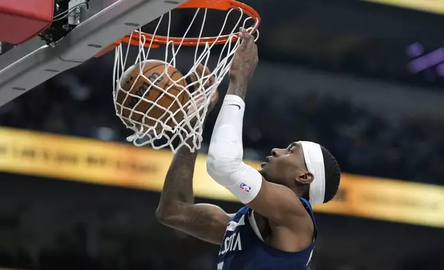 Minnesota Timberwolves forward Jaden McDaniels (3) slam dunks during the first half of an NBA basketball game against the Dallas Mavericks Wednesday, Jan. 22, 2025, in Dallas. (AP Photo/LM Otero)