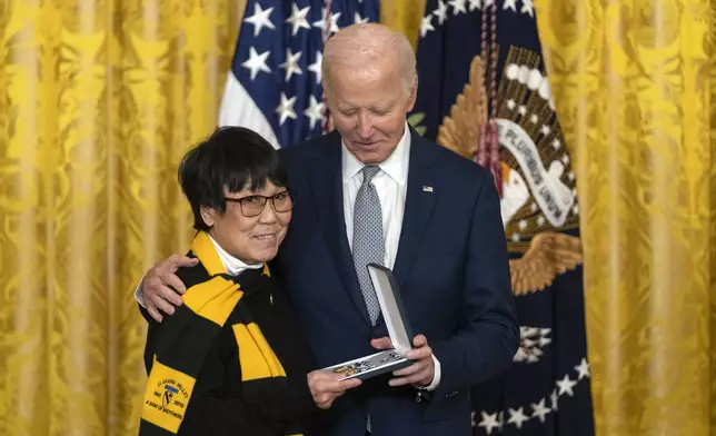 President Joe Biden awards the Presidential Citizens Medal to Gracie Galloway on behalf of Joseph Galloway during a ceremony in the East Room at the White House, Thursday, Jan. 2, 2025, in Washington. (AP Photo/Mark Schiefelbein)