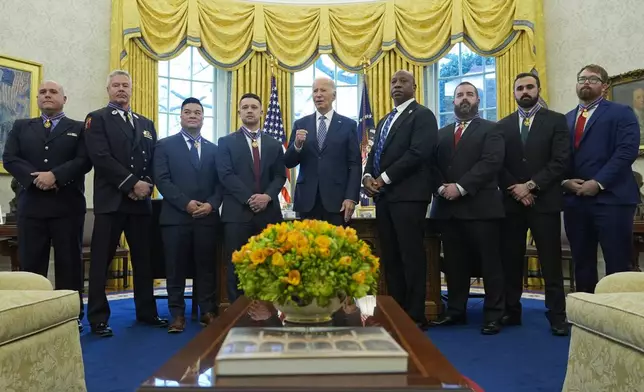 President Joe Biden, center, poses for a photo with Medal of Valor honorees in the Oval Office of the White House in Washington, Friday, Jan. 3, 2025. Honorees are, from left, Lt. John Vanderstar of the New York City Fire Department, Firefighter Brendan Gaffney of the New York City Fire Department, Sgt. Tu Tran, of the Lincoln, Neb. Police Department, Det. Michael Collazo, of the Nashville, Tenn. Police Department, Chief John Drake, receiving on behalf of Officer Rex Engelbert, of the Nashville, Tenn. Police Department, Sgt. Jeffrey Mathes, of the Nashville, Tenn. Police Department, Det. Zachary Plese, of the Nashville, Tenn. Police Department, and Det. Ryan Cagle, of the Nashville, Tenn. Police Department. (AP Photo/Susan Walsh)