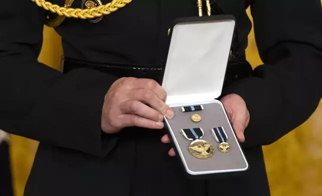 An official holds medals during an event for President Joe Biden to award the Presidential Citizens Medal to recipients in the East Room at the White House, Thursday, Jan. 2, 2025, in Washington. (AP Photo/Mark Schiefelbein)