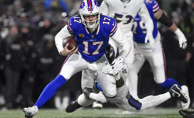 Buffalo Bills quarterback Josh Allen (17) is tackled by Baltimore Ravens defensive tackle Nnamdi Madubuike (92) during the first quarter of an NFL divisional playoff football game, Sunday, Jan. 19, 2025, in Orchard Park, N.Y. (AP Photo/Adrian Kraus)