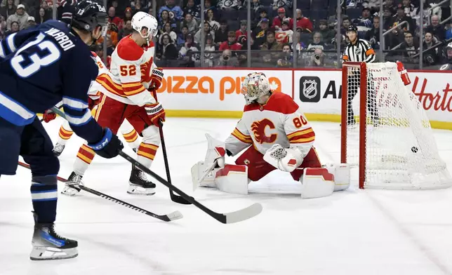 Winnipeg Jets' Gabriel Vilardi scores on Calgary Flames goaltender Dan Vladar (80) during the second period of an NHL hockey game in Winnipeg, Manitoba, Sunday, Jan. 26, 2025. (Fred Greenslade/The Canadian Press via AP)