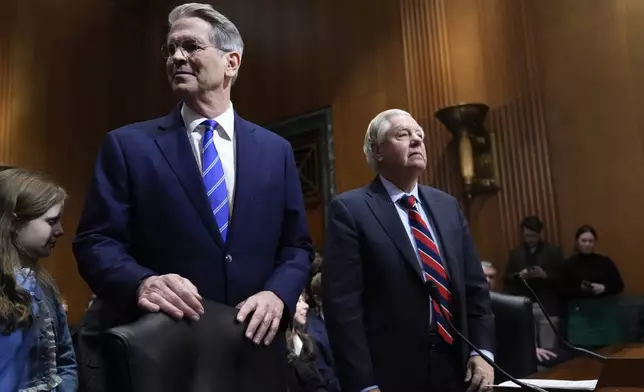 Scott Bessent, left, President-elect Donald Trump's choice to be Secretary of the Treasury, arrives with Sen. Lindsey Graham, R-S.C., right, before the Senate Finance Committee for his confirmation hearing, at the Capitol in Washington, Thursday, Jan. 16, 2025. (AP Photo/J. Scott Applewhite)