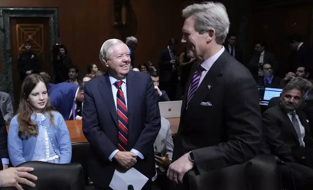 Sen. Lindsey Graham, R-S.C., left, talks with John Freeman, right, husband of Scott Bessent, President-elect Donald Trump's choice to be Secretary of the Treasury, before the Senate Finance Committee for Bessent's confirmation hearing, at the Capitol in Washington, Thursday, Jan. 16, 2025. (AP Photo/Ben Curtis)