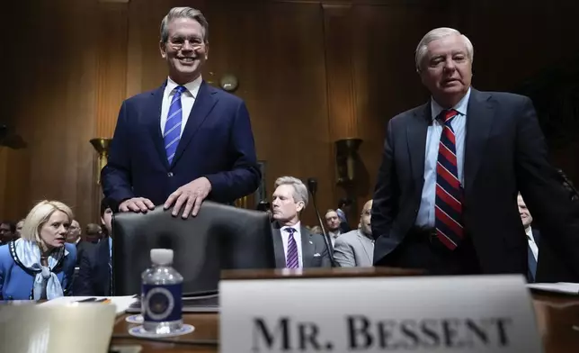 Scott Bessent, left, President-elect Donald Trump's choice to be Secretary of the Treasury, arrives with Sen. Lindsey Graham, R-S.C., right, before the Senate Finance Committee for his confirmation hearing, at the Capitol in Washington, Thursday, Jan. 16, 2025. (AP Photo/Ben Curtis)