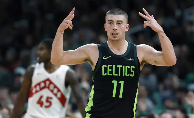 Boston Celtics' Payton Pritchard (11) celebrates his three-pointer in front of Toronto Raptors' Davion Mitchell (45) during the first half of an NBA basketball game, Tuesday, Dec. 31, 2024, in Boston. (AP Photo/Michael Dwyer)