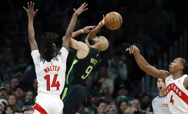 Boston Celtics' Derrick White (9) tries to get a shot off against Toronto Raptors' Ja'Kobe Walter (14) during the first half of an NBA basketball game, Tuesday, Dec. 31, 2024, in Boston. (AP Photo/Michael Dwyer)