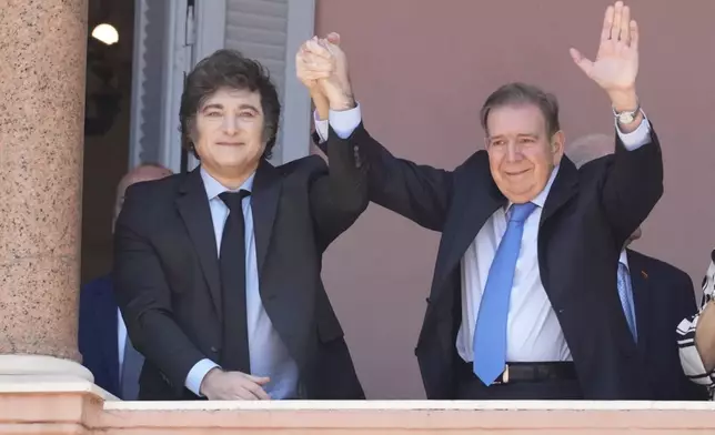 Venezuela's opposition leader Edmundo Gonzalez Urrutia, right, and Argentine President Javier Milei hold hands from the government house balcony in Buenos Aires, Argentina, Saturday, Jan. 4, 2025. Gonzalez, who claims he won the 2024 presidential election and is recognized by some countries as the legitimate president-elect, traveled from exile in Madrid to Argentina. (AP Photo/Natacha Pisarenko)