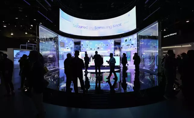 People look at a display of Samsung screens and products at the CES tech show Tuesday, Jan. 7, 2025, in Las Vegas. (AP Photo/Abbie Parr)