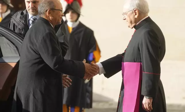 Leslie Voltaire, the president of Haiti's Transition Council, left, is welcomed by Father Leonardo Sapienza ahead of his meeting with Pope Francis at the Vatican, Saturday, Jan. 25, 2025. (AP Photo/Gregorio Borgia)