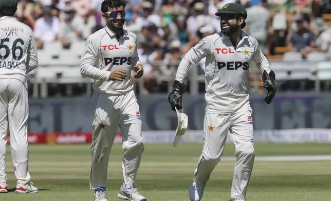 Pakistan's Kamran Ghulam, left, and Pakistan's Mohammad Rizwan enjoy a light hearted moment during the second day of the second test match between South Africa and Pakistan in Cape Town, South Africa, Saturday, Jan. 4, 2025. (AP Photo/Halden Krog)